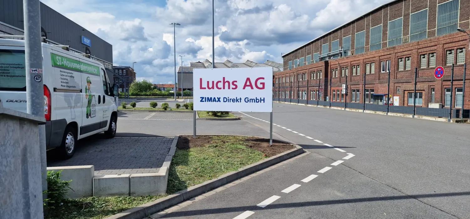 Pflasterarbeiten rund um den kleinen Garten der Luchs AG ZIMAX Direkt GmbHc Schild an der Straße