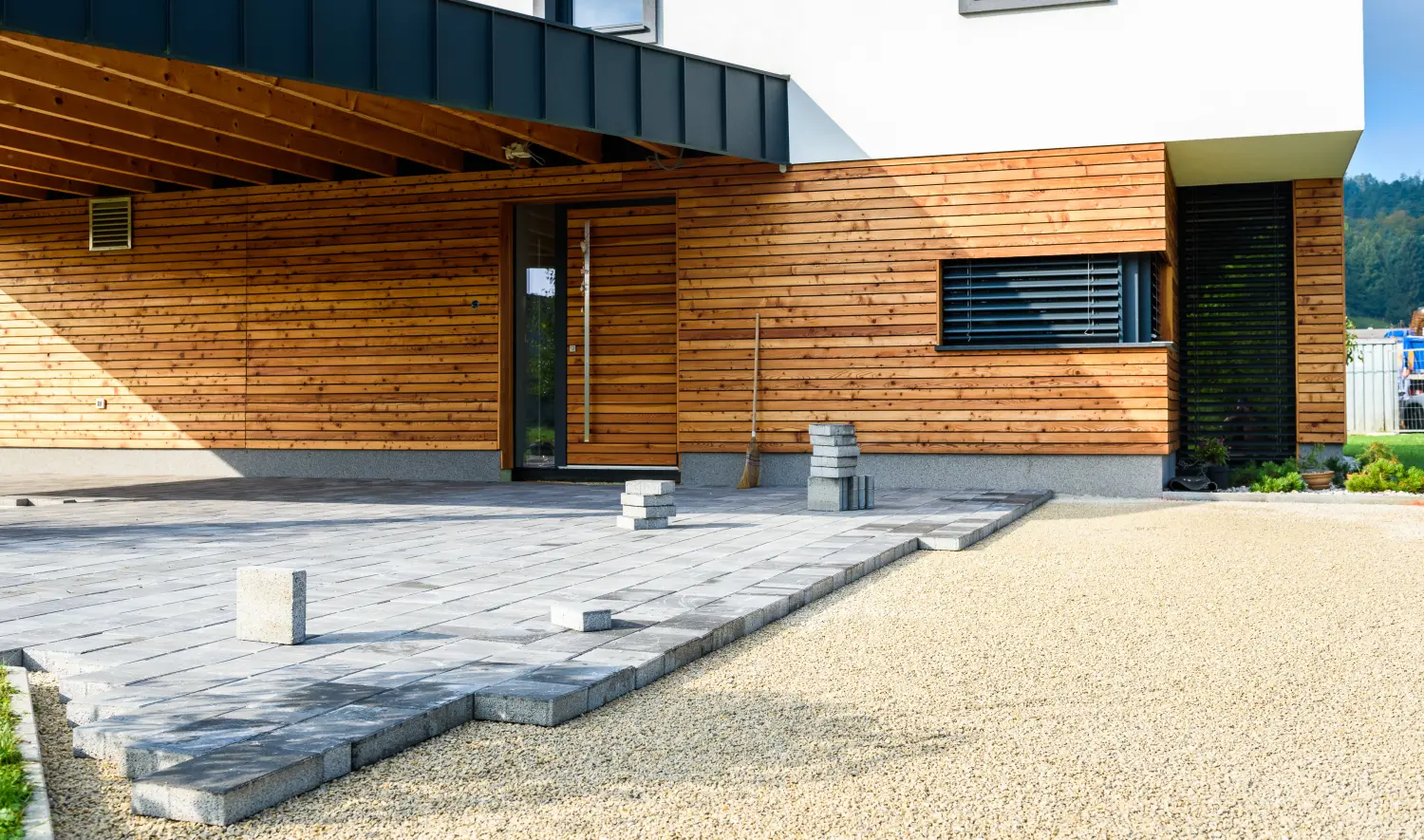 Verlegung von grauen Betonplatten im Innenhof des Hauses, Einfahrt und Terrasse.